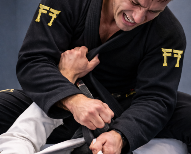 2 jiujitsukas qui s'affrontent l'un en noir en position de montée et un en blanc en demi garde